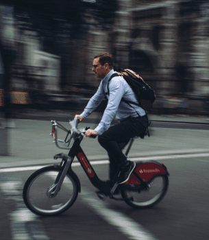 person with business suit riding a bike